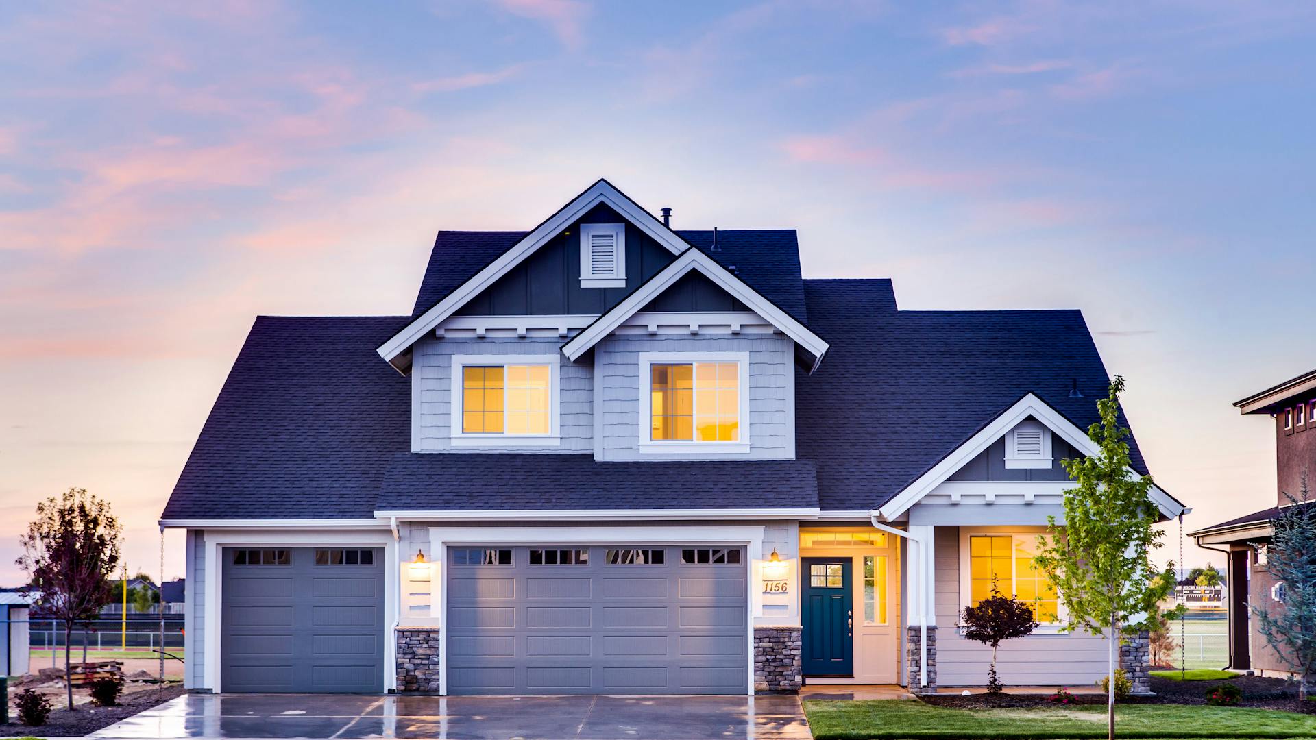 Houston residential home at dusk with warm interior light glowing through windows, representing the safety and comfort of reliable electrical work